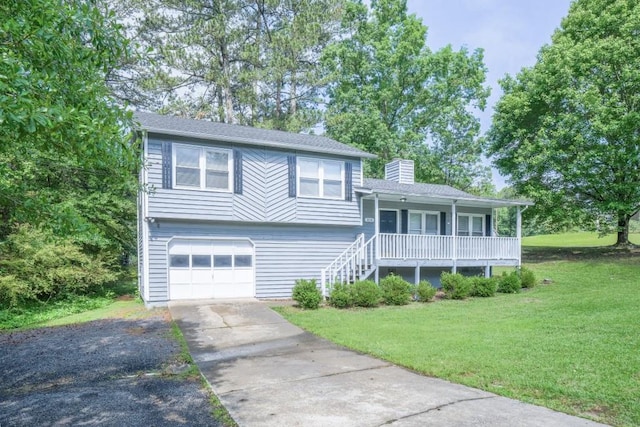 2650 Montego Dr, Buford, GA 30519 - tri-level home featuring a porch, a front lawn, a chimney, a garage, and concrete driveway
