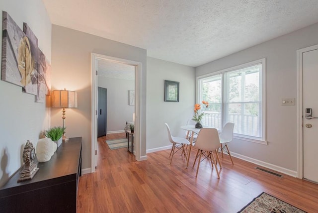 2650 Montego Dr, Buford, GA 30519 - dining area featuring light wood-style floors, a textured ceiling, and baseboards