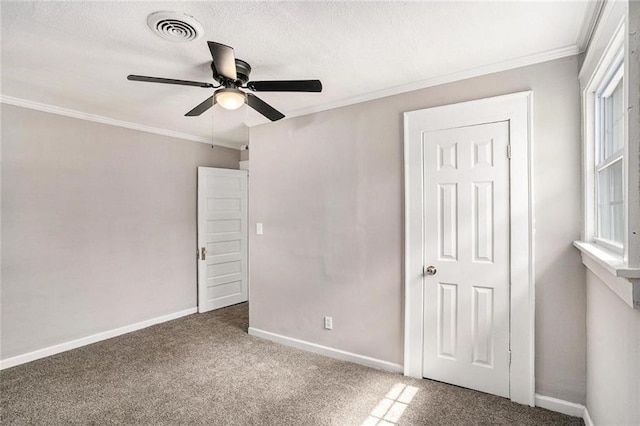 unfurnished bedroom with a textured ceiling, visible vents, baseboards, ornamental molding, and carpet