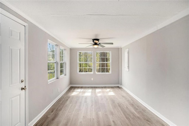 unfurnished room featuring crown molding, light wood finished floors, a textured ceiling, and baseboards