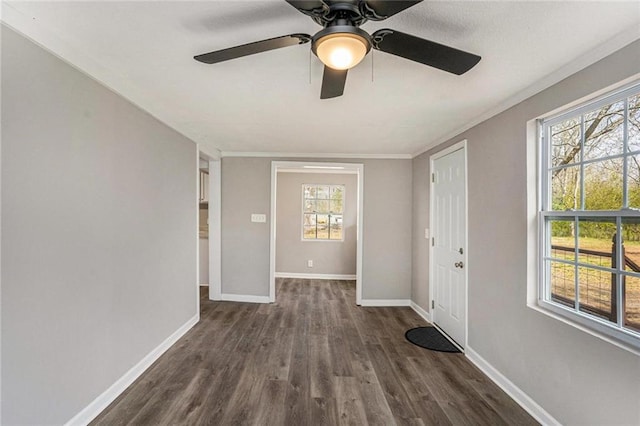 interior space with dark wood-type flooring, crown molding, and baseboards