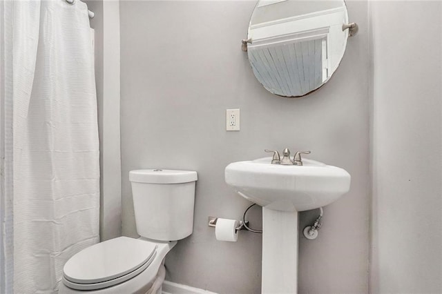 full bath with curtained shower, baseboards, and toilet