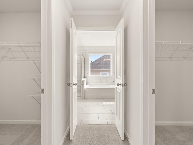 corridor featuring baseboards and carpet
