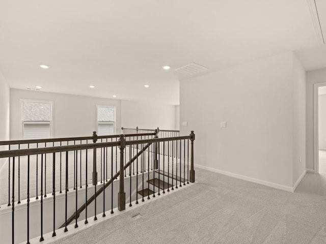 hallway featuring an upstairs landing, carpet floors, baseboards, visible vents, and recessed lighting