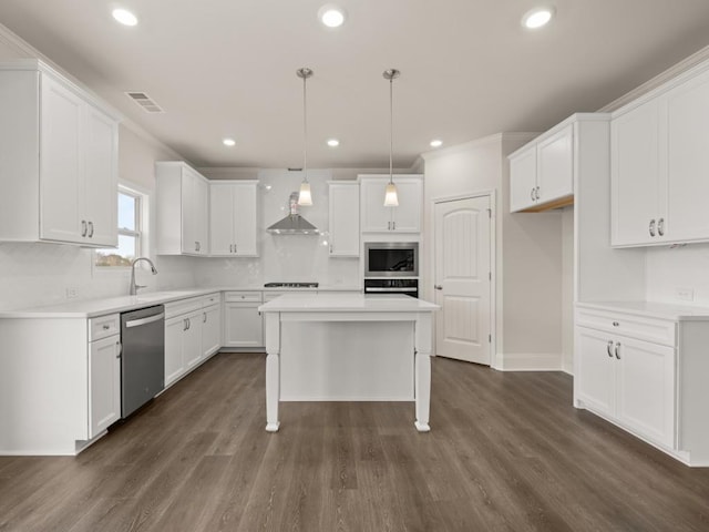 kitchen featuring white cabinets, visible vents, wall chimney exhaust hood, and appliances with stainless steel finishes