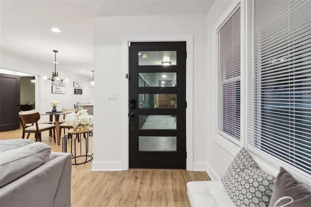 entryway with a chandelier and light hardwood / wood-style flooring