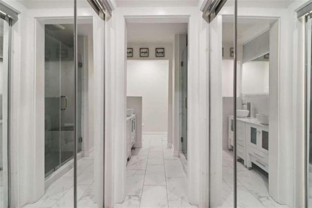 bathroom featuring a shower with door and vanity