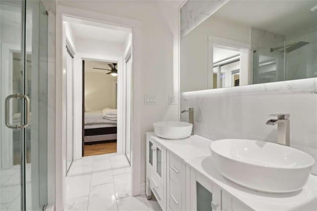 bathroom featuring ceiling fan, vanity, and walk in shower