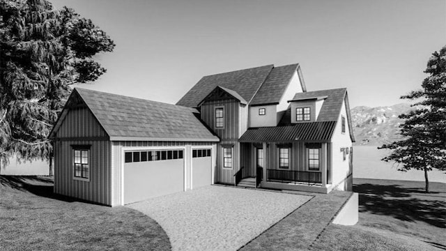 view of front of property featuring a mountain view, a garage, a front yard, and covered porch