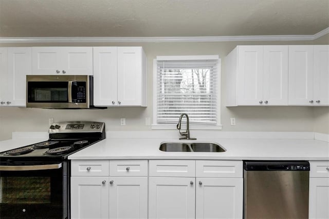 kitchen featuring light countertops, appliances with stainless steel finishes, a sink, and white cabinets