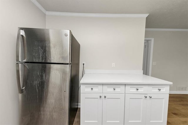 kitchen featuring visible vents, dark wood-type flooring, freestanding refrigerator, light countertops, and white cabinetry