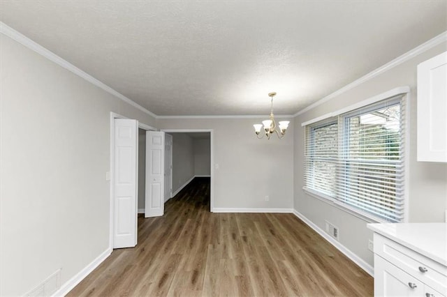 unfurnished dining area with baseboards, light wood-style flooring, visible vents, and an inviting chandelier