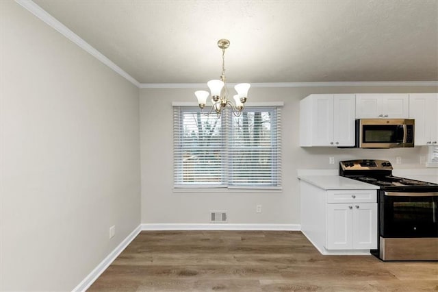 kitchen with appliances with stainless steel finishes, light wood-style floors, and white cabinets