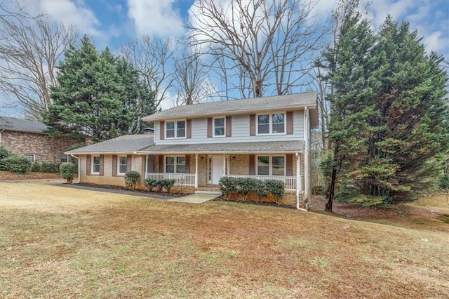 view of front of home with covered porch, a front lawn, and brick siding