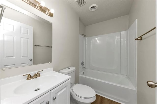 full bathroom featuring visible vents, a textured ceiling, toilet, and vanity