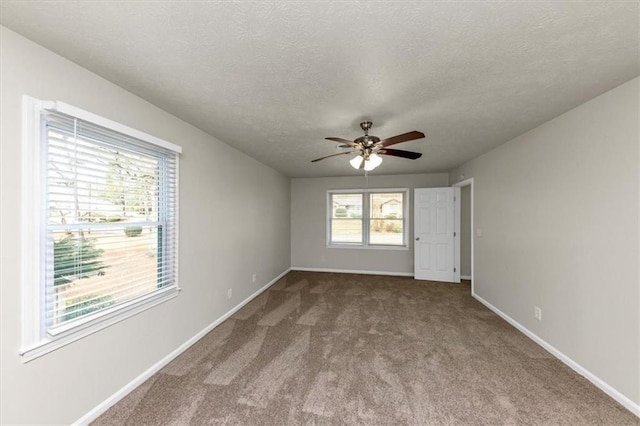 unfurnished room featuring carpet, a textured ceiling, baseboards, and a ceiling fan