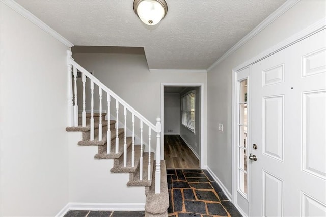 foyer entrance featuring stairway, baseboards, a textured ceiling, and ornamental molding