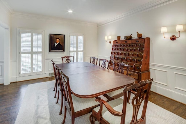 dining space with ornamental molding and dark hardwood / wood-style flooring