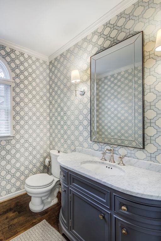 bathroom with vanity, hardwood / wood-style flooring, ornamental molding, and toilet