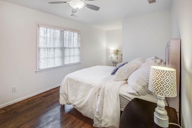 bedroom with dark hardwood / wood-style flooring and ceiling fan