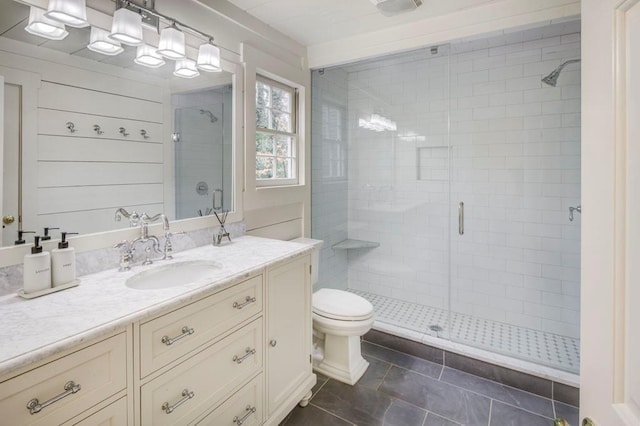 bathroom featuring vanity, a shower with door, tile patterned floors, and toilet