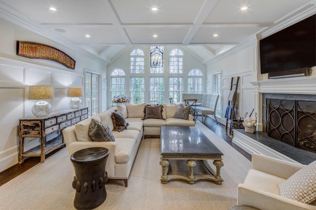 living room with beam ceiling, coffered ceiling, a fireplace, and light wood-type flooring