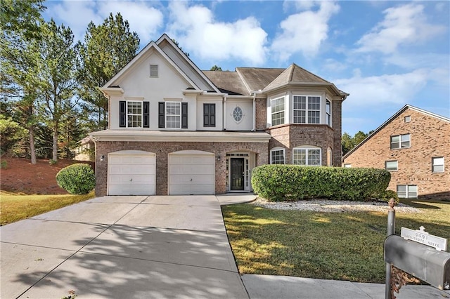 traditional-style house featuring brick siding, a garage, stucco siding, a front yard, and driveway