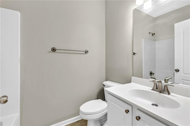 bathroom featuring vanity, baseboards, washtub / shower combination, and toilet