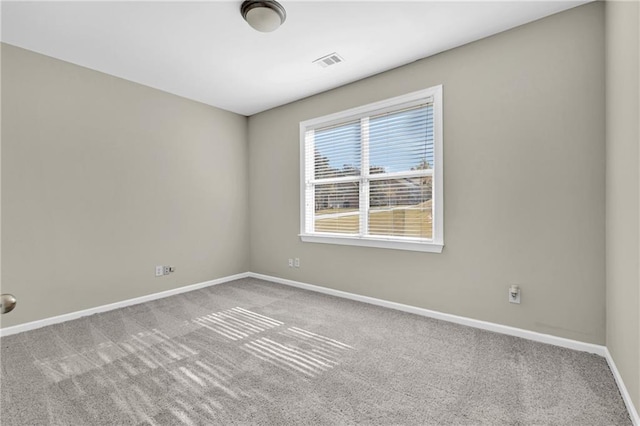 unfurnished room with baseboards, carpet flooring, and visible vents
