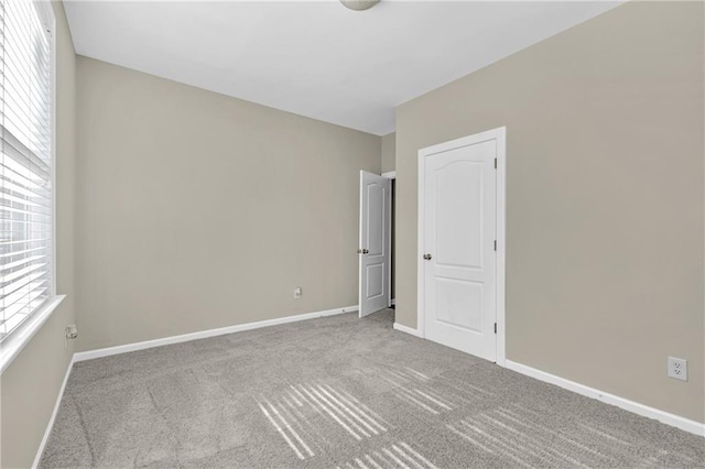 empty room with carpet floors and baseboards