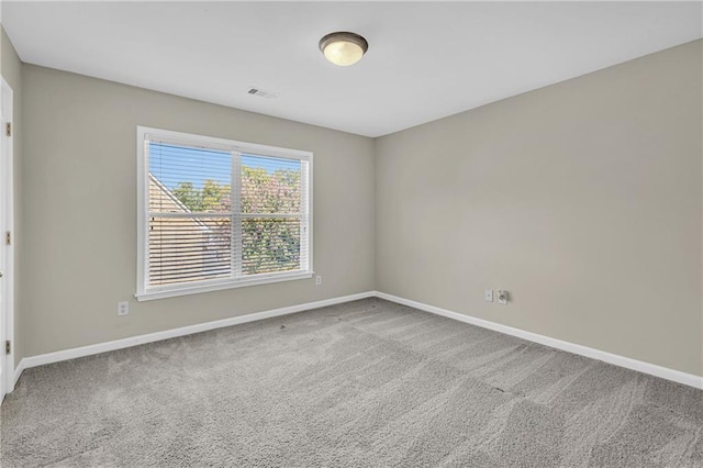carpeted empty room with visible vents and baseboards