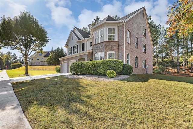 traditional-style home featuring brick siding, an attached garage, a front yard, and concrete driveway