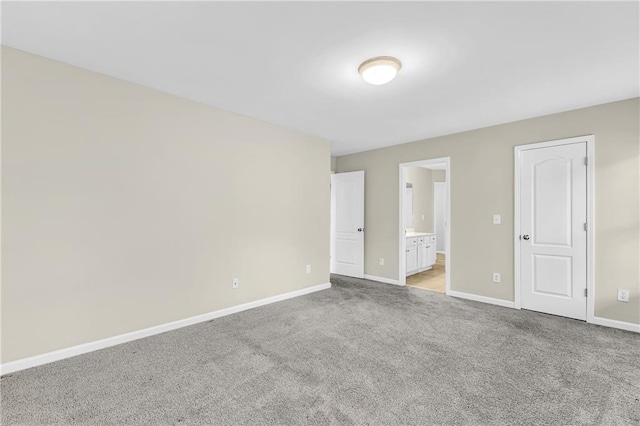unfurnished room featuring baseboards and light carpet