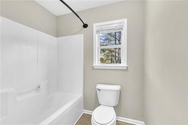 bathroom featuring baseboards and toilet
