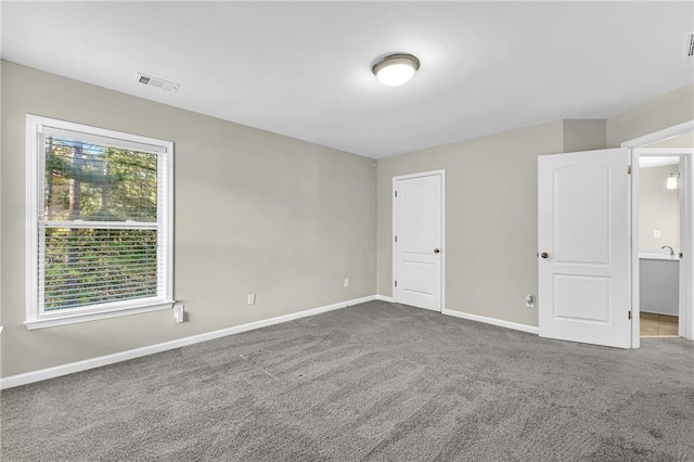 unfurnished bedroom with visible vents, carpet flooring, and baseboards