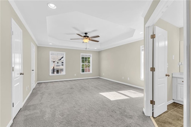 interior space with carpet floors, ceiling fan, a tray ceiling, and recessed lighting