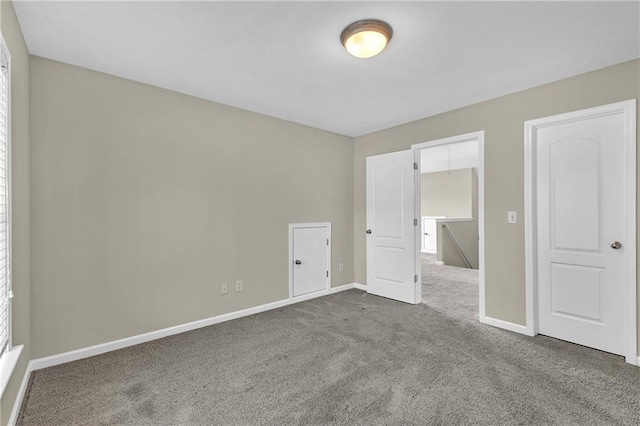 unfurnished bedroom with carpet floors and baseboards