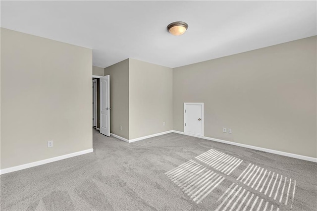 empty room featuring carpet flooring and baseboards