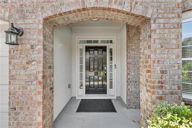doorway to property featuring brick siding