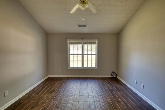 unfurnished room with dark wood finished floors, visible vents, a textured ceiling, and baseboards