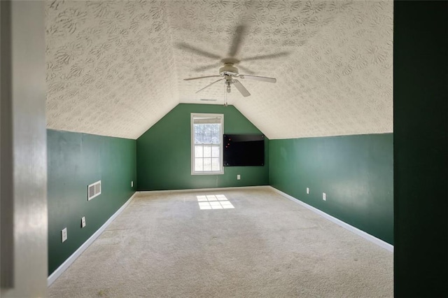 bonus room with baseboards, a textured ceiling, carpet floors, and vaulted ceiling