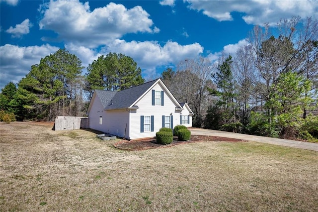 view of side of home with concrete driveway and a yard