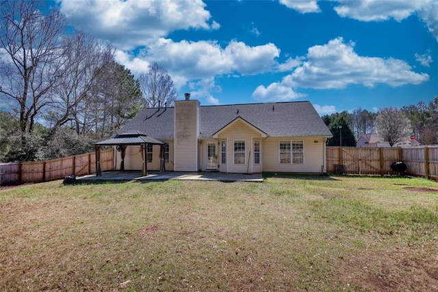 rear view of house with a gazebo, a fenced backyard, a yard, and a patio