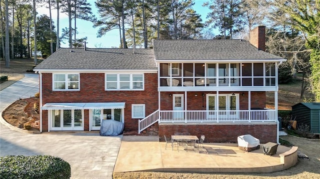 rear view of house featuring a patio and a sunroom