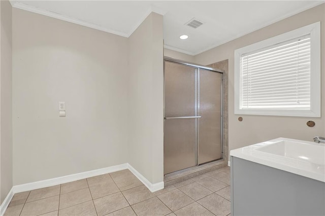 bathroom featuring tile patterned flooring, crown molding, a shower with shower door, and vanity