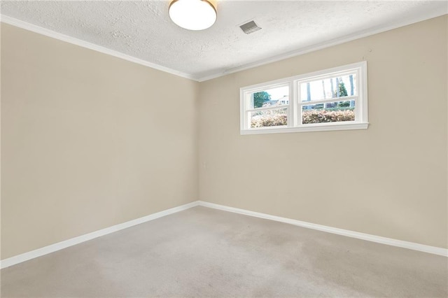 carpeted empty room with a textured ceiling and ornamental molding