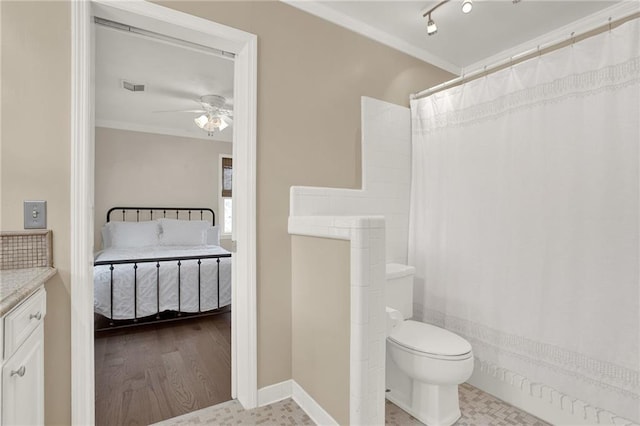 bathroom featuring ceiling fan, toilet, vanity, and crown molding