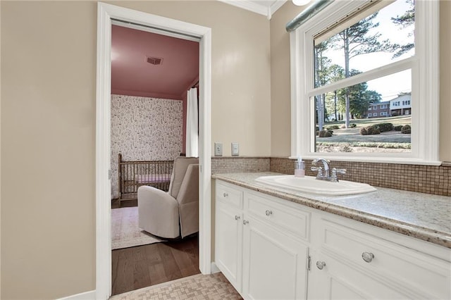 bathroom featuring vanity, wood-type flooring, and crown molding