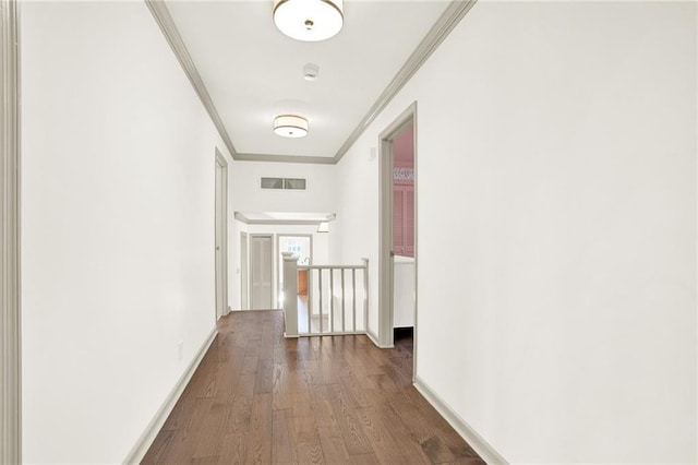 corridor with ornamental molding and hardwood / wood-style flooring