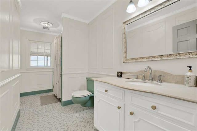 bathroom featuring toilet, crown molding, and vanity